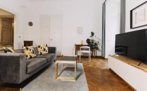 a living room with a couch and a flat screen tv at L'Arco Trieste studio living 1 in Trieste