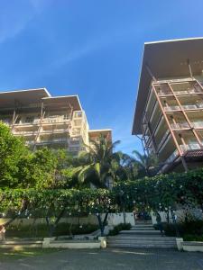 a building with stairs and palm trees in front of it at Maison Brise Condominium Unit Pico De Loro Nasugbu in Nasugbu
