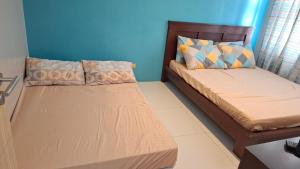 two beds in a room with blue walls at Maison Brise Condominium Unit Pico De Loro Nasugbu in Nasugbu