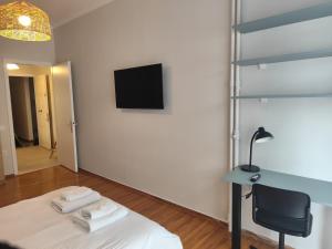 a room with a bed and a tv on a wall at Parastaseis One Bedrooom Flat Georges Square in Patra