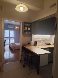 a kitchen with a table and a room with a bed at Parastaseis One Bedrooom Flat Georges Square in Patra