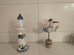 eine Glasvitrine mit einer Vogelstatue und einem Leuchtturm in der Unterkunft Beetzseeperle in Brandenburg an der Havel