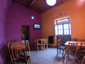 an empty room with tables and chairs and a window at Kamaq Hostel in Humahuaca