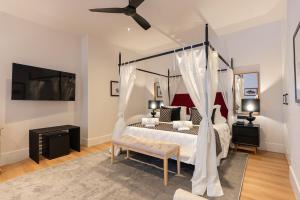 a bedroom with a canopy bed with a ceiling fan at Hotel Duquesa Golf Club in San Luis de Sabinillas