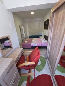 a room with two beds and a chair and a mirror at Villa Nela in Tivat