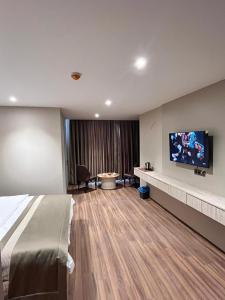 a hotel room with a bed and a flat screen tv at Palmero Butik Otel in Çiftlikköy