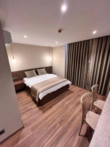 a bedroom with a bed and a desk and a chair at Palmero Butik Otel in Çiftlikköy