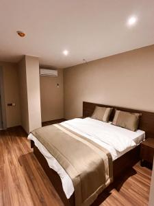 a bedroom with a large bed with white sheets at Palmero Butik Otel in Çiftlikköy