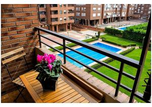 a vase of pink flowers sitting on a bench on a balcony at Apto La Estambrera IV Wifi y Aire Acondicionado in Logroño
