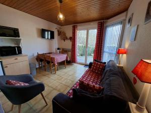 a living room with a couch and a table at Hameau des chaumes vue panoramique in La Bresse