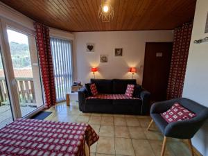 a living room with a couch and a chair at Hameau des chaumes vue panoramique in La Bresse