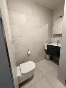 a white bathroom with a toilet and a sink at Urban Nest Studio - Cloche d'Or in Luxembourg