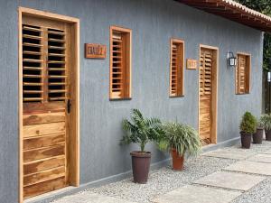a blue house with wooden doors and potted plants at Chalé 1 - próximo à igreja do céu in Viçosa do Ceará