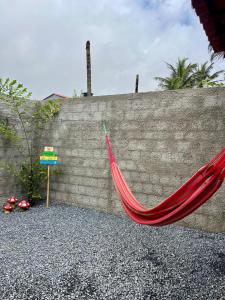 a red hammock leaning against a brick wall at Chalé 1 - próximo à igreja do céu in Viçosa do Ceará