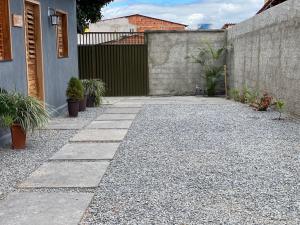 a stone walkway with potted plants and a fence at Chalé 1 - próximo à igreja do céu in Viçosa do Ceará +1 photo