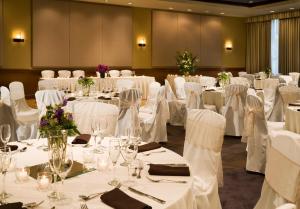 a banquet room with white tables and chairs with white linens at Riverplace Hotel in Portland