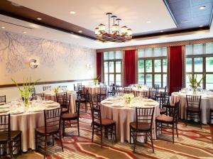 a banquet room with tables and chairs and a chandelier at Riverplace Hotel in Portland