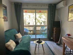 a living room with a green couch and a window at Studio Paradise entre mer et pins in Saint-Raphaël