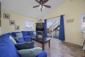 a living room with a blue couch and a table at 7039 - A Wave From It All in Rodanthe