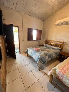 a bedroom with two beds and a window in it at Quintal de minas Pousada in Delfinópolis +59 photos