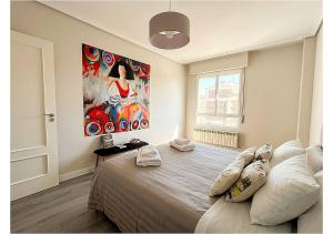 a bedroom with a large bed with a painting on the wall at Apto La Estambrera IV Wifi y Aire Acondicionado in Logroño