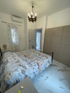 a bedroom with a bed and a chandelier at Apartment with garden PERLA NERONIANA in Anzio