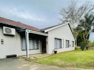 a white house with a fan and a yard at 16 on Les De Jager in Pietermaritzburg