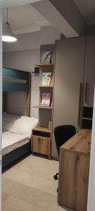 a bedroom with a bed and a desk and a chair at Parastaseis City Flat Central in Patra
