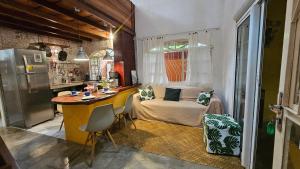 a kitchen with a table and a couch in a room at Casas Vila Encantada Refúgio, conforto e natureza, apenas 2 min da avenida in Alto Paraíso de Goiás