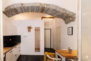a kitchen and dining room with a large stone archway at L'arco Trieste studio living 2 in Trieste