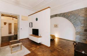 a living room with a bed and a tv at L'arco Trieste studio living 2 in Trieste