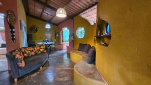 a living room with a couch and a table at Casas Vila Encantada Refúgio, conforto e natureza, apenas 2 min da avenida in Alto Paraíso de Goiás