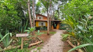 a house in the woods with a sign in front of it at Casas Vila Encantada Refúgio, conforto e natureza, apenas 2 min da avenida in Alto Paraíso de Goiás