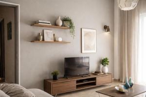 a living room with a flat screen tv on a wooden entertainment center at Midway Point Apts in Heraklio