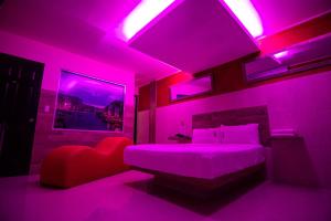 a bedroom with a bed with purple lighting at COSMOPOLITAN Autohotel in Boca del Río