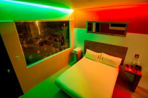 a room with a bed with green and red lights at COSMOPOLITAN Autohotel in Boca del Río