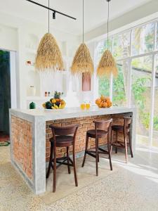 a kitchen with a counter with chairs and fruits on it at Celestine's Hideaway in Kamburugamuwa
