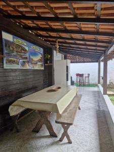 a kitchen with a table and a refrigerator at Wood house casa privada in Abraão