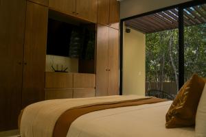 a bedroom with a large bed and a large window at Casa Edén in Xpu Ha +33 photos