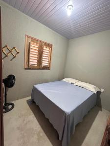 a bedroom with a bed and a window at Chalé 1 - próximo à igreja do céu in Viçosa do Ceará