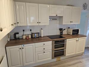 a kitchen with white cabinets and a counter top at M4 Victoria Hub in Newport