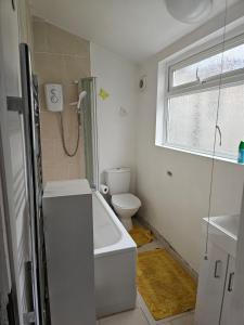 a bathroom with a bath tub and a toilet at M4 Victoria Hub in Newport