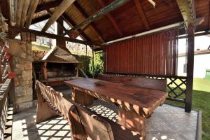 an outdoor patio with a wooden table and a grill at Apartment Tadey in Fužine