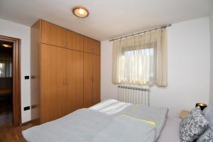 a bedroom with a bed and a wooden cabinet at Apartment Tadey in Fužine