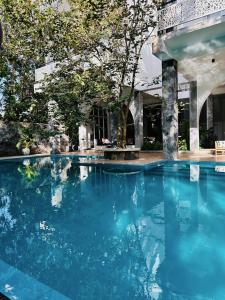 a swimming pool with blue water in front of a building at Celestine's Hideaway in Kamburugamuwa