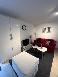 a living room with a bed and a red couch at Apartment avec cours in Bonny-sur-Loire