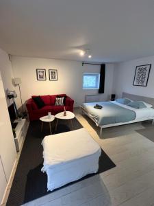 a bedroom with a bed and a red couch at Apartment avec cours in Bonny-sur-Loire