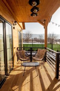 a wooden deck with two chairs and a table on it at Natural cottage in Saguramo