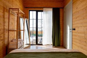 a bedroom with a bed and a large window at Natural cottage in Saguramo