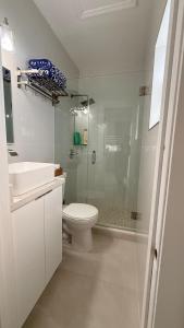 a white bathroom with a toilet and a shower at Comfortable modern apartment- central location. in Miami +45 photos